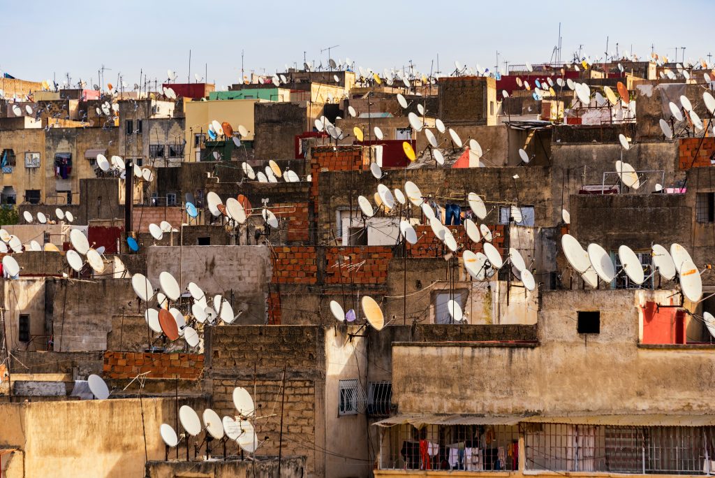 A collection of satellites on rooftops, satellite TV broadcasting