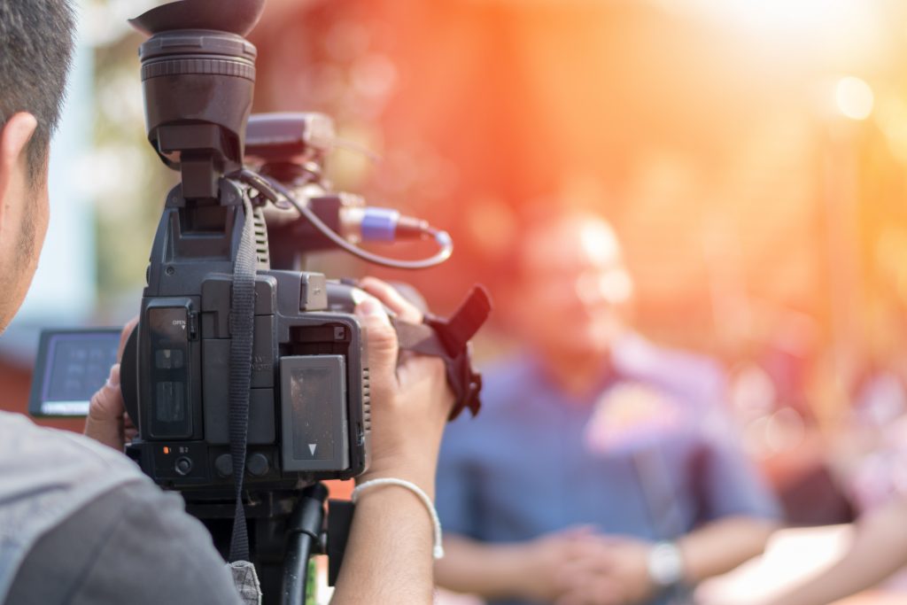 A camera man recoding a news reporter